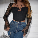 Bustier noir en dentelle ajourée avec manches longues et col halter
